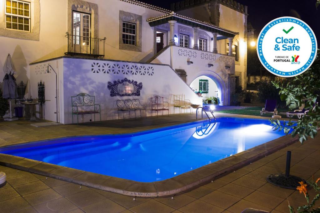 a swimming pool in front of a house at night at Casa do Infante in Ferreira do Alentejo