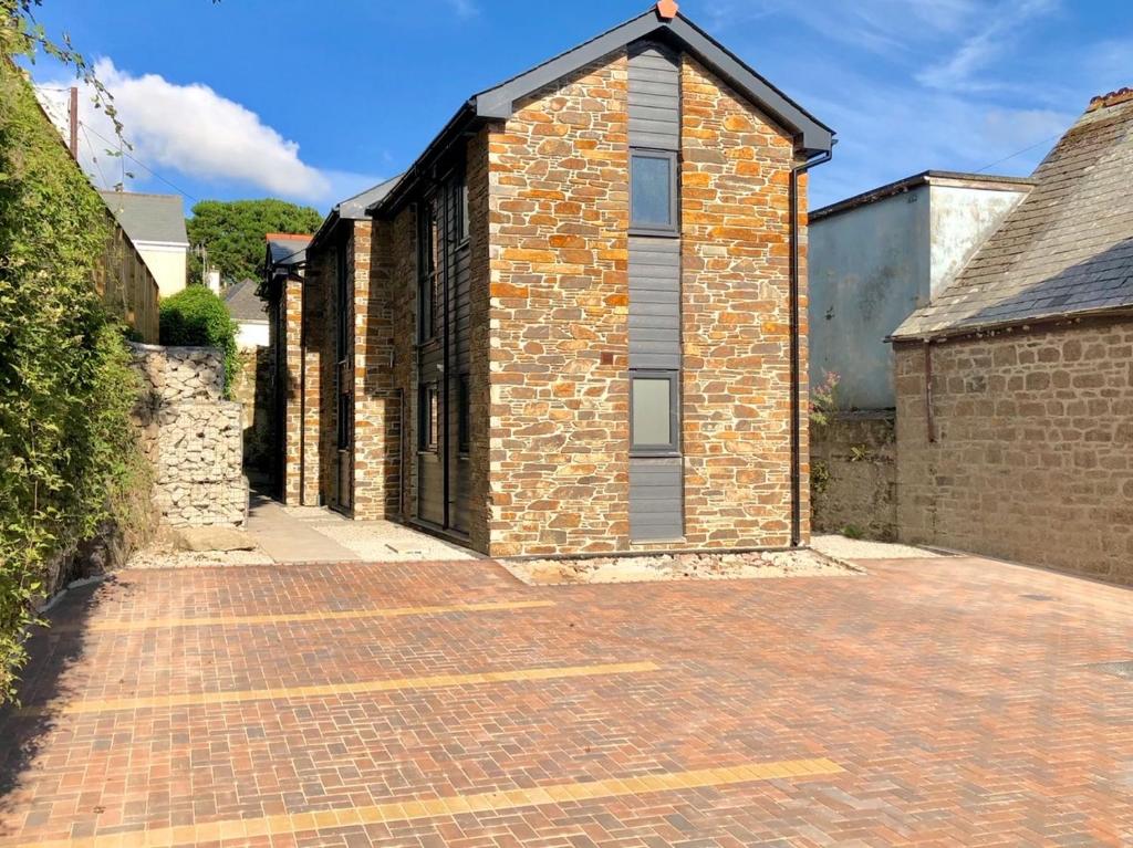 an old brick building with a brick driveway at Oliver's Yard in Helston