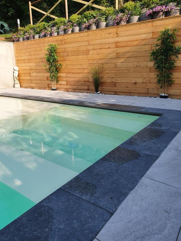 a swimming pool in a backyard with a wooden fence at Mimosa Apartments in Soiano del Lago
