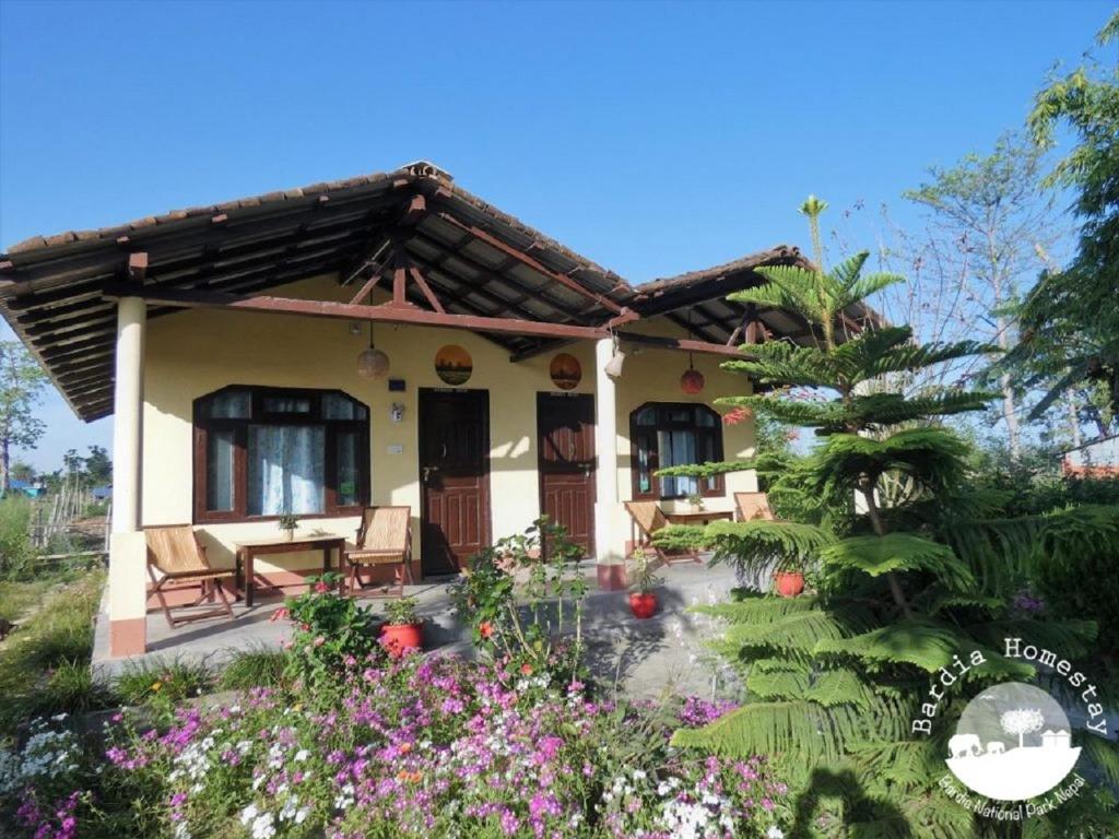 una casa con jardín y flores delante de ella en Bardia Homestay Pvt. Ltd., en Bhurkīā