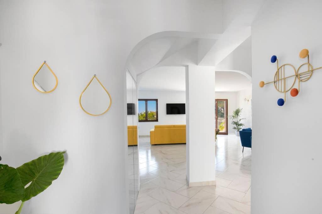 salon z białymi ścianami i żółtą kanapą w obiekcie Villa Capo D'Arco w mieście Massa Lubrense