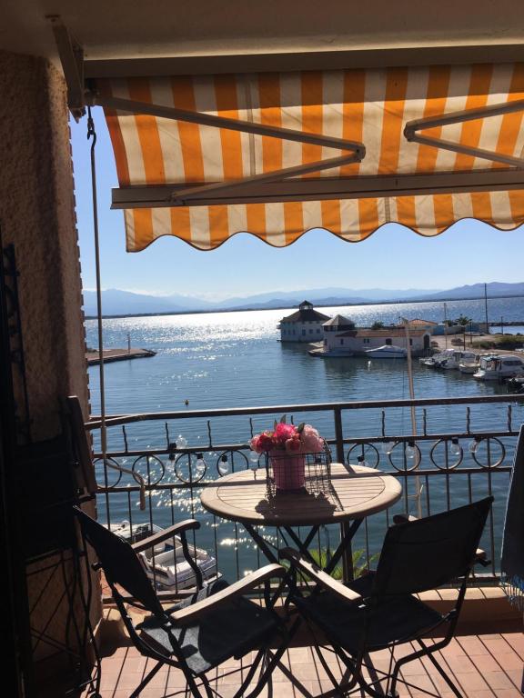 een tafel op een balkon met uitzicht op het water bij Appartement F3 avec jolie vue in Le Barcarès