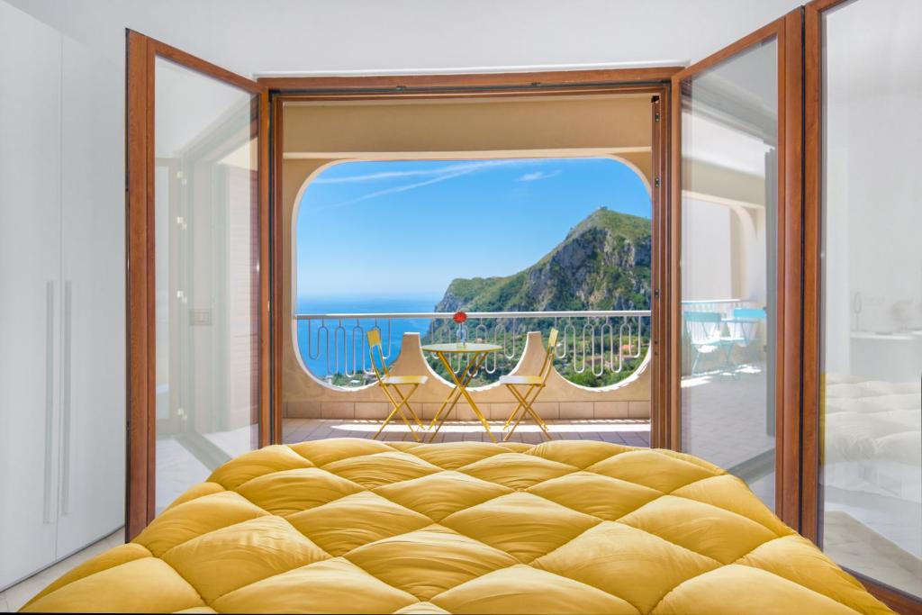a bedroom with a large window with a view of the ocean at Villa Capo D'Arco in Massa Lubrense