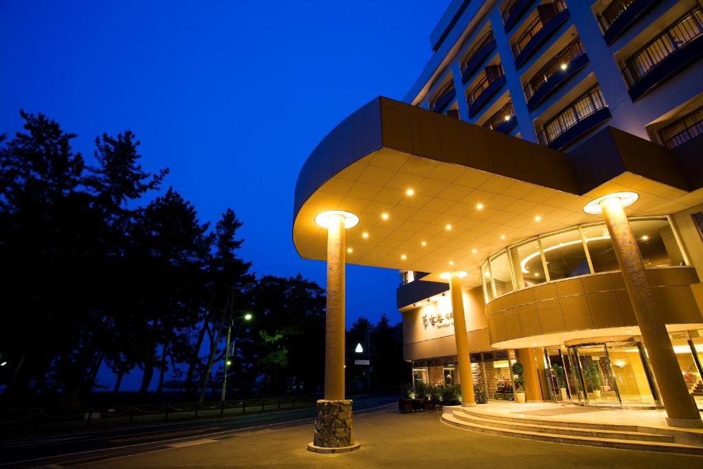 un edificio con luces de la calle delante de él por la noche en Yumekaiyu Awajishima, en Sumoto