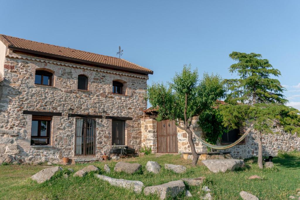 Santa María la Real de NievaにあるLA CASA DEL BUHOの木の前の古い石造家