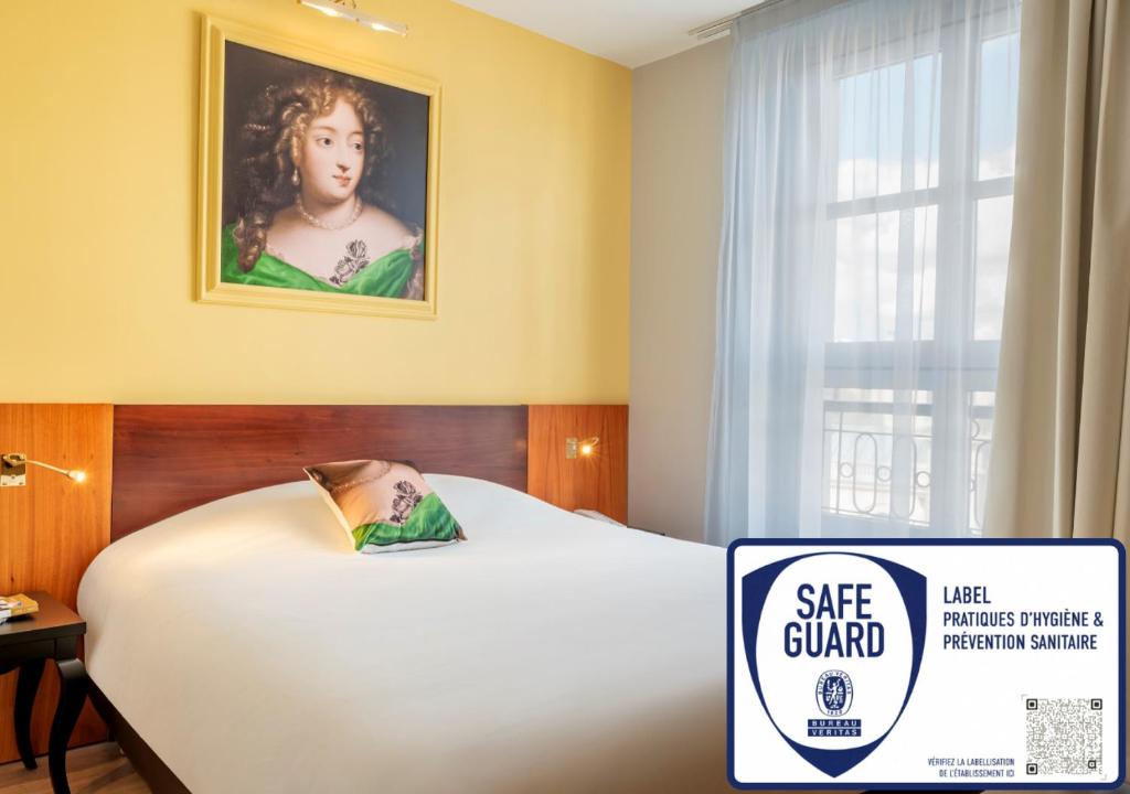 a bed in a hotel room with a sale guard sign at Hotel des Lys in Versailles