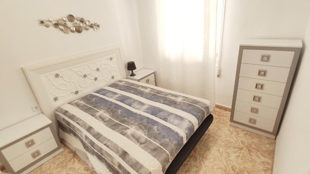 1 dormitorio blanco con 1 cama y vestidor en Beautiful flat with sea view and sound of the surf, en Santa Pola