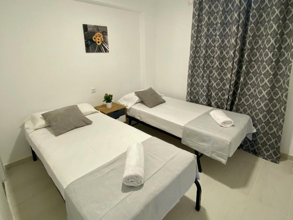 two beds in a hospital room with a window at APARTBEACH AGUSTINA ARAGON CLIMATIZADO y VISTAS PLAYA in Salou