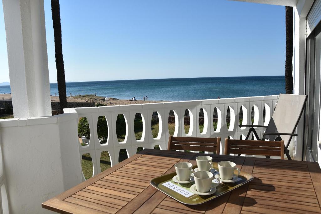 デニアにあるHoliday Beach Apartmentのビーチを望むバルコニー(コーヒーカップ付きのテーブル付)