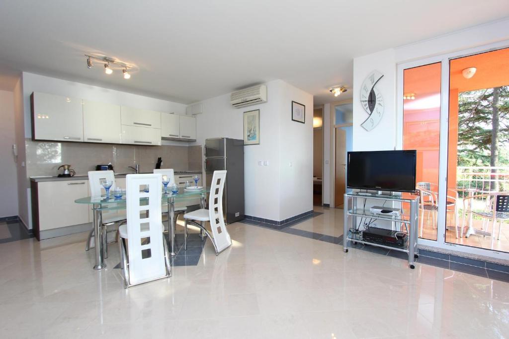 a kitchen and dining room with a table and a television at Apartment Nautica in Novigrad Istria