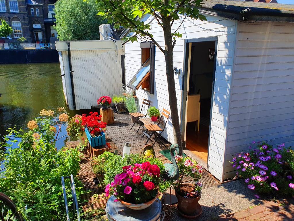 a house with a bunch of flowers on a deck at Romantic quiet studio on the canal in Amsterdam