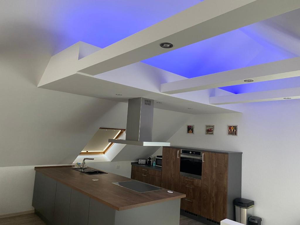 cocina con techo con luz azul en Traumhafte Dachgeschosswohnung, en Königslutter am Elm