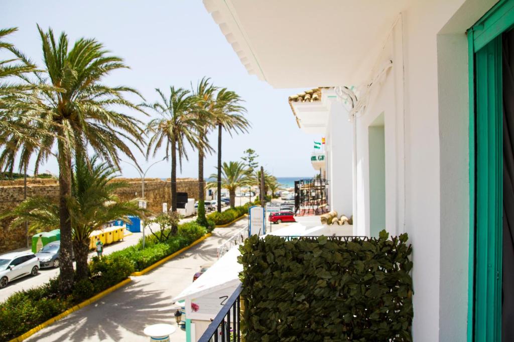 uma varanda com vista para uma rua com palmeiras em Alquiler Turístico Avenida Playa em Zahara de los Atunes