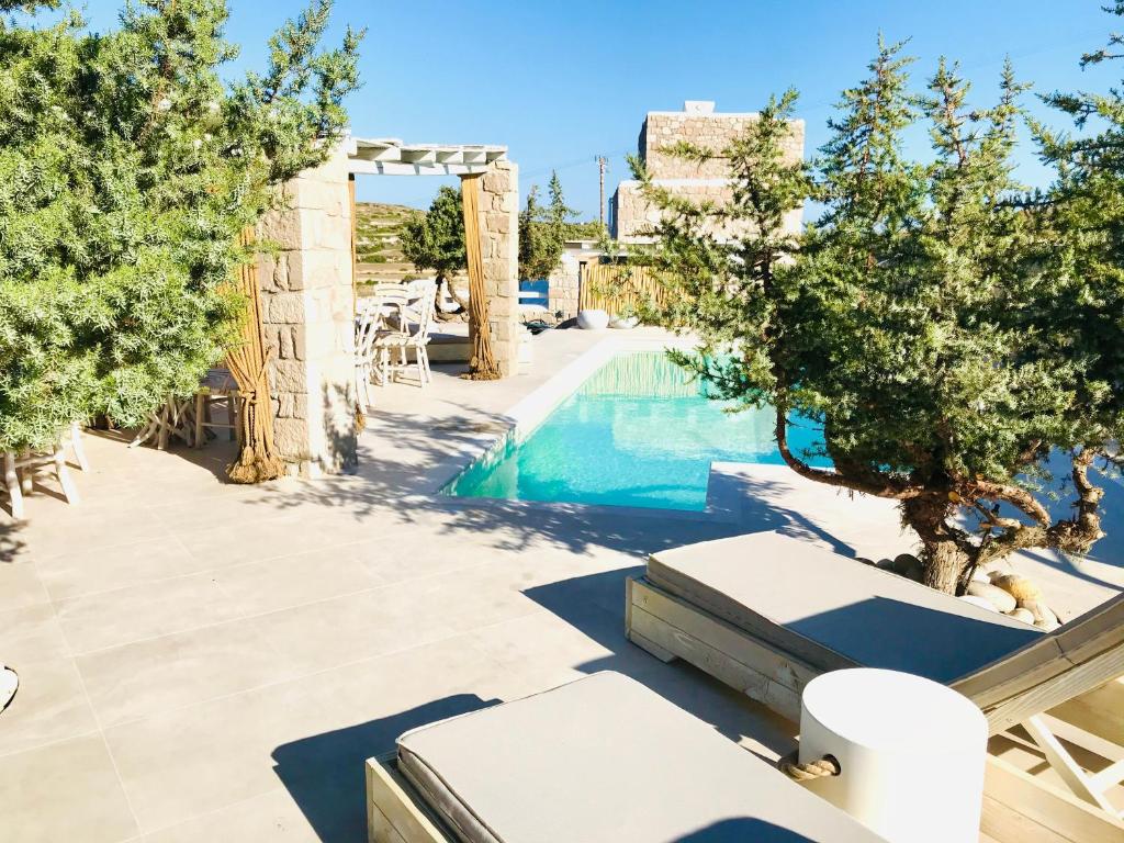 una piscina en un complejo con árboles y sillas en Milo Milo Suites en Mandrakia