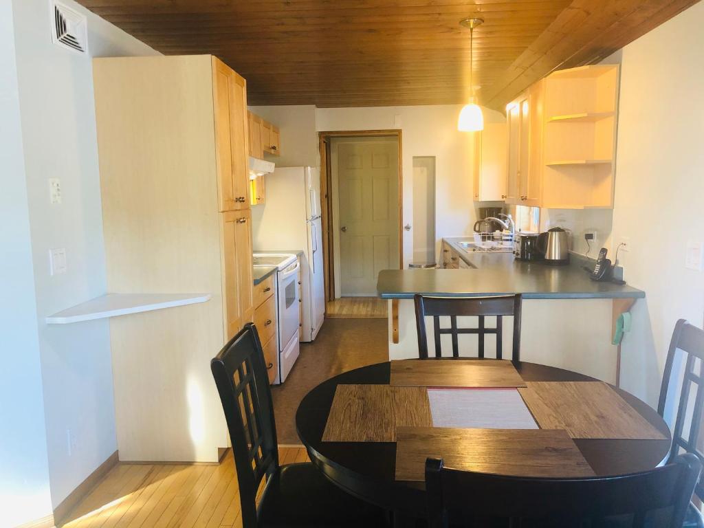 a kitchen and dining room with a table and chairs at Midnight Sun Vacation Home in Whitehorse