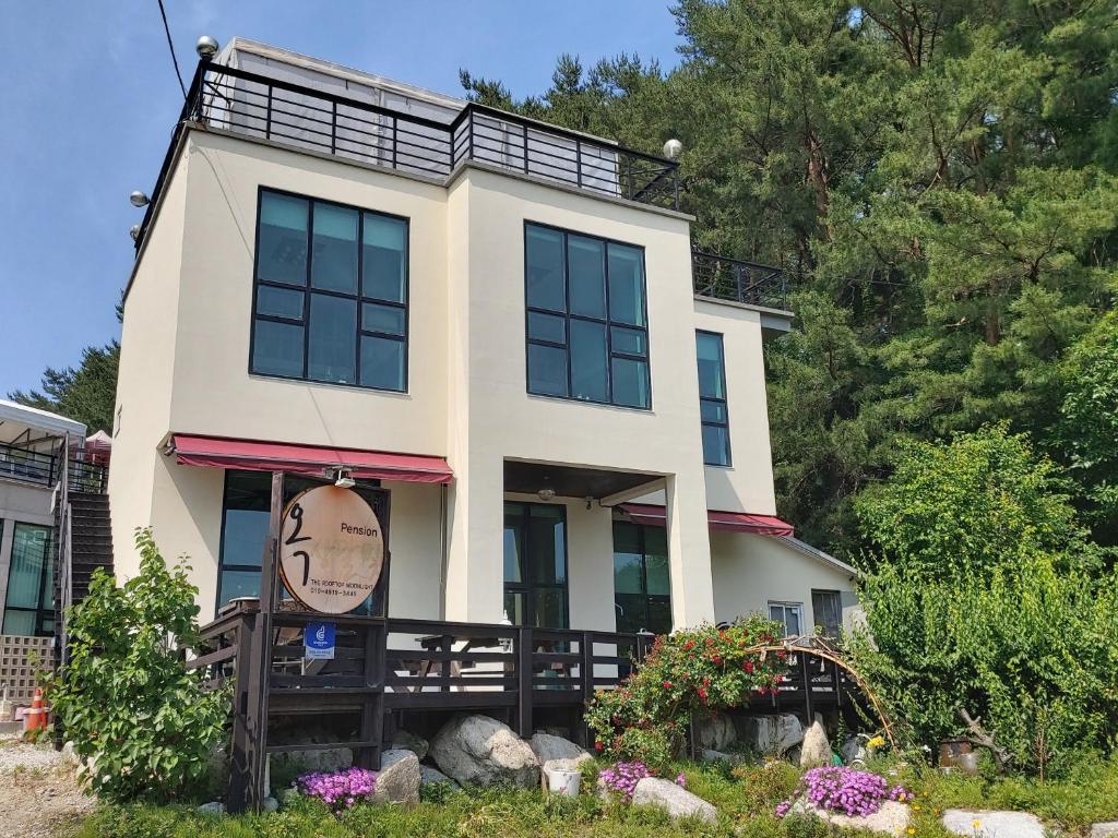 une maison avec un panneau devant dans l'établissement Rooftop Moonlight Pension, à Gangneung