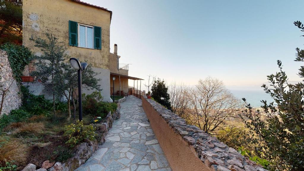 uma casa no lado de uma colina com uma estrada em B&B La Canonica - Svegliarsi a Verezzi em Borgio Verezzi