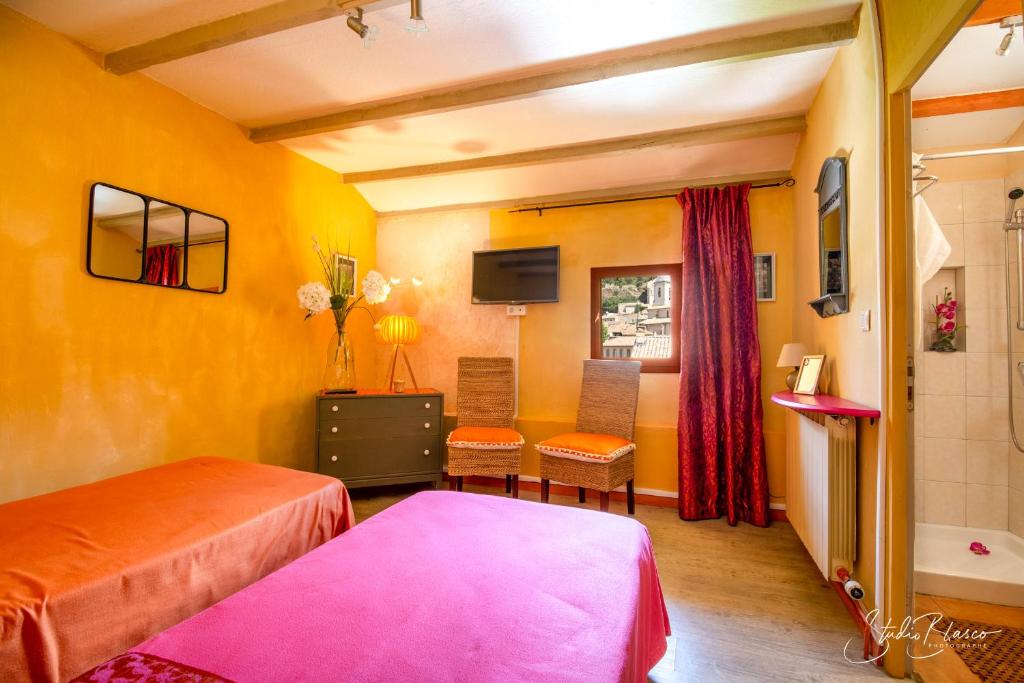 a room with two beds and a bathroom with a tub at Le Relais Des Dentelles in Beaumes-de-Venise