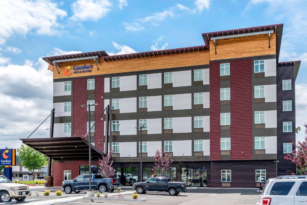 a large building with cars parked in a parking lot at Comfort Inn & Suites Lakewood by JBLM in Lakewood