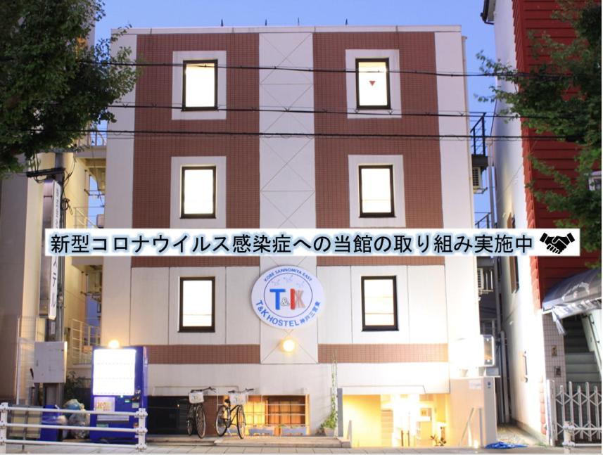 a building with a sign in front of it at T and K Hostel Kobe Sannomiya East in Kobe