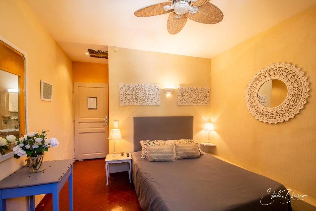 a bedroom with a bed and a ceiling fan at Le Relais Des Dentelles in Beaumes-de-Venise