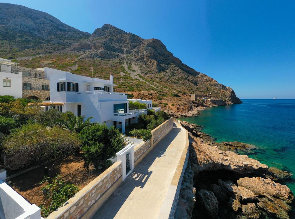 una casa blanca en una colina junto al océano en Spilia Retreat en Kamares