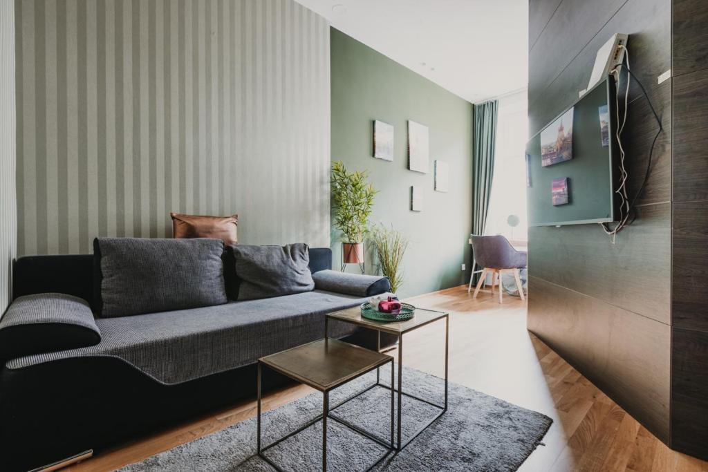 ein Wohnzimmer mit einem Sofa und einem Tisch in der Unterkunft ZEUS Design Apartments Lovely Home Vienna in Wien