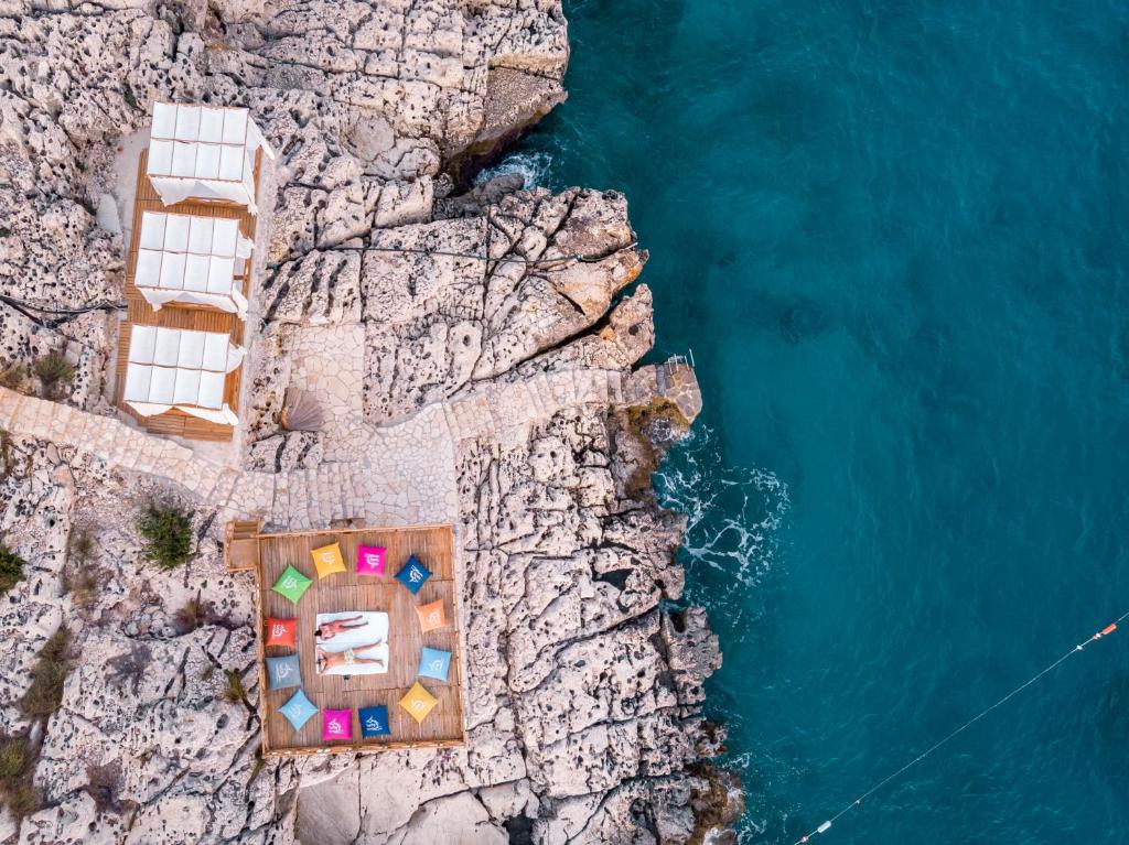 an aerial view of a resort on a cliff next to the water at Lycia Hotel in Kaş