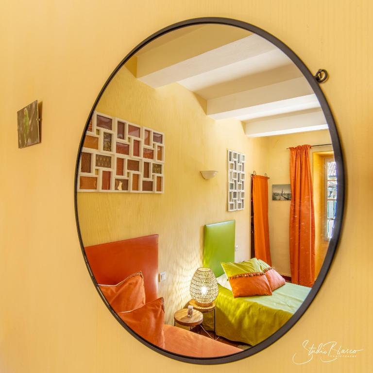 a mirror reflection of a bedroom with a bed at Le Relais Des Dentelles in Beaumes-de-Venise