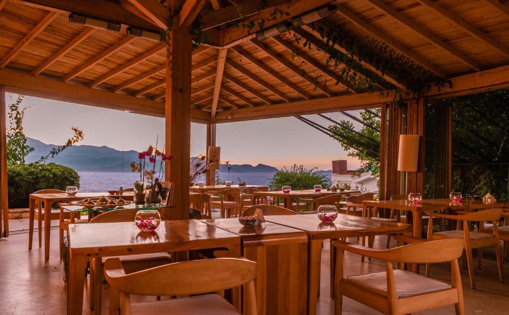 a restaurant with tables and chairs and a view of the ocean at Lycia Hotel in Kaş