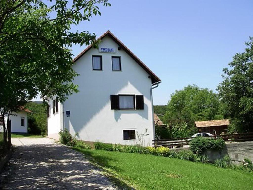 Una casa blanca con una ventana en el costado. en House Vranić, en Rakovica