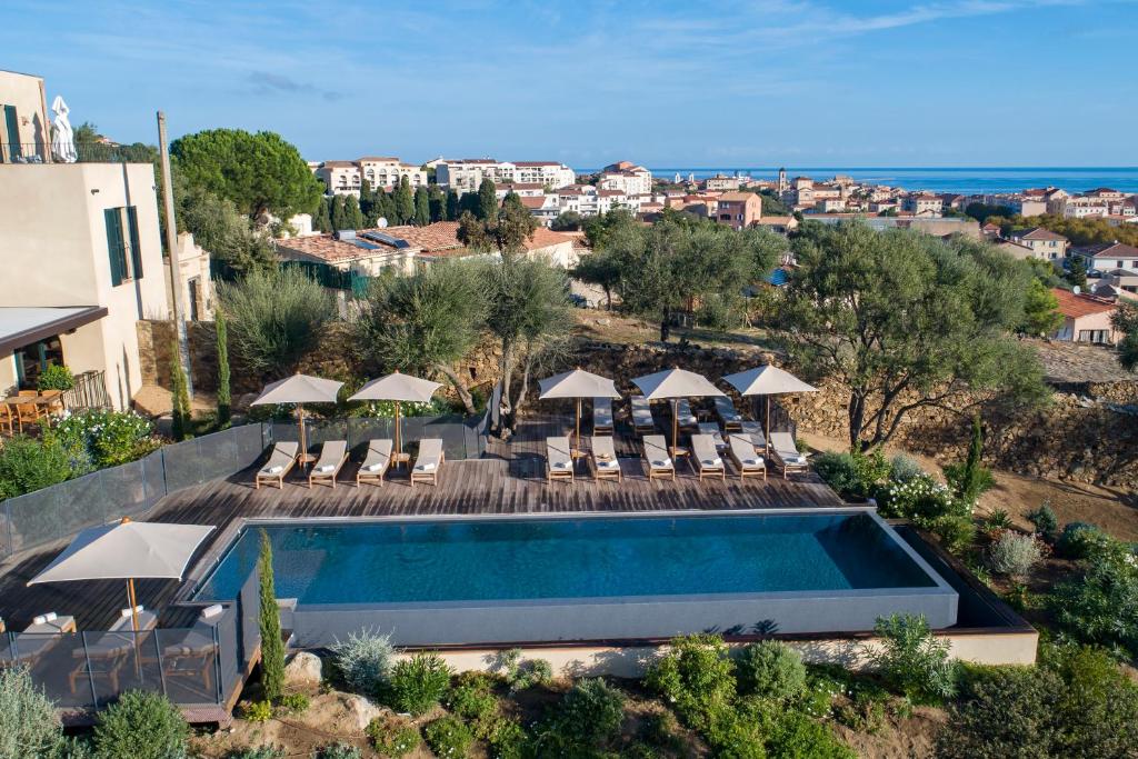 an aerial view of a pool with chairs and umbrellas at Hôtel Restaurant Villa Joséphine in LʼÎle-Rousse