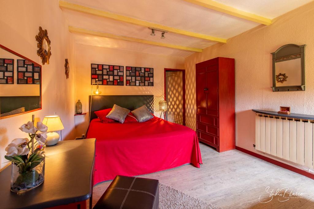 a bedroom with a red bed and a desk at Le Relais Des Dentelles in Beaumes-de-Venise