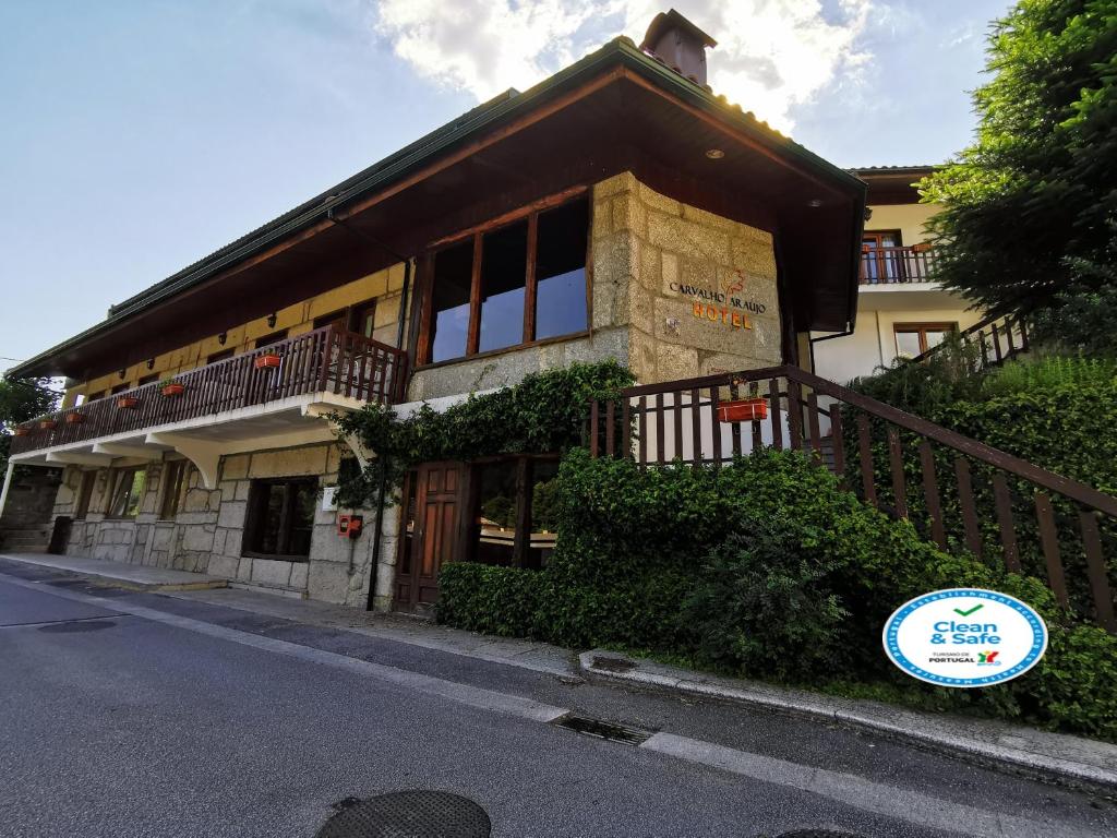 un bâtiment avec un balcon sur le côté d'une rue dans l'établissement Hotel Carvalho Araujo, à Gerês