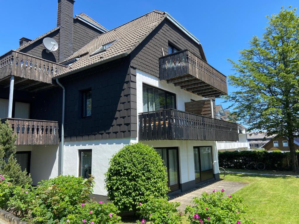 ein Haus mit schwarzem Dach und Balkonen darauf in der Unterkunft Ferienwohnung Fichtenweg in Winterberg
