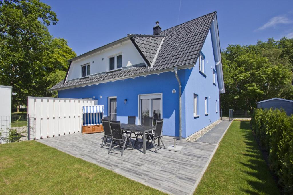 a blue house with a table and chairs on a deck at Ferienhaus Luna Haus - Terrasse, Garten, Sauna in Breege
