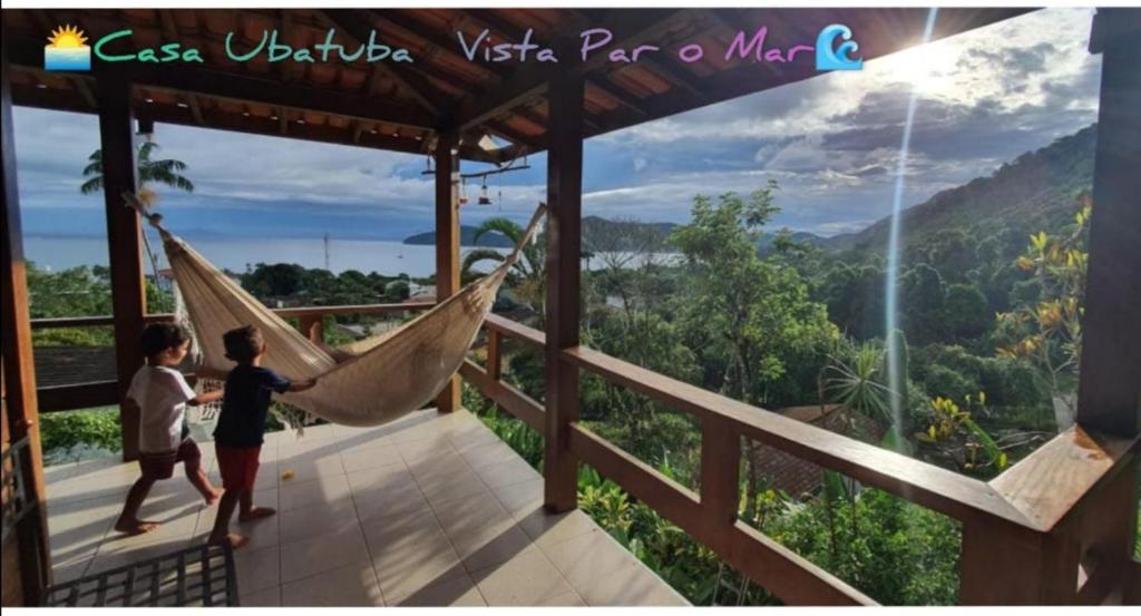 烏巴圖巴的住宿－Casa Ubatuba Vista para o Mar，几个孩子在阳台上的吊床上玩耍