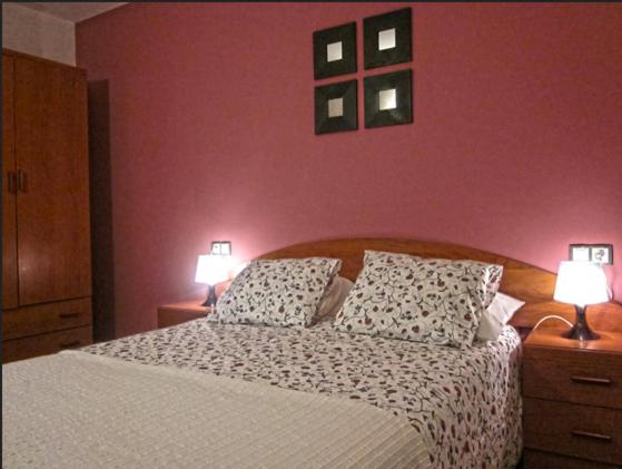 1 dormitorio con 1 cama grande y 2 lámparas. en Apartamentos Los Mayos de Albarracín, en Albarracín