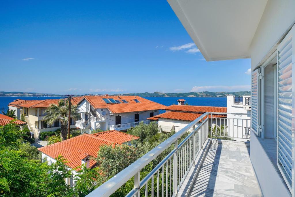 balcón con vistas a las casas y al océano en Studios Garifalia, en Ammoulianí
