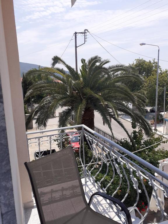 einen Balkon mit einem Stuhl und einer Palme in der Unterkunft Diane Luxury Rooms in Skala Kallirachis