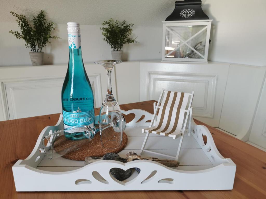 eine Flasche Wein auf einem Tisch mit einem Stuhl in der Unterkunft KleinAberFein an der Nordseeküste in Schweindorf