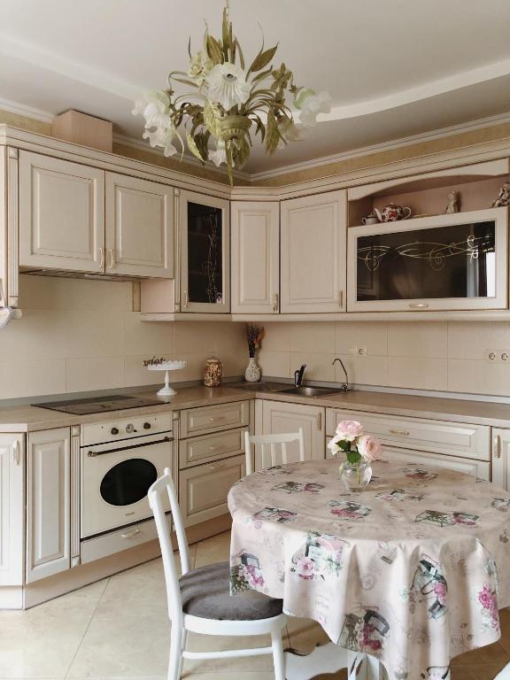 a kitchen with white cabinets and a table with chairs at Kuchonka in Chornomorsk