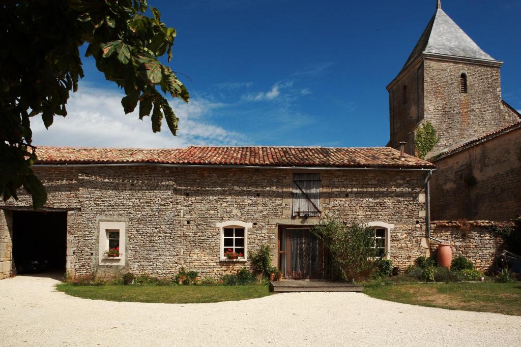 un antiguo edificio de ladrillo con una torre y una iglesia en La Grange, en Vanzay