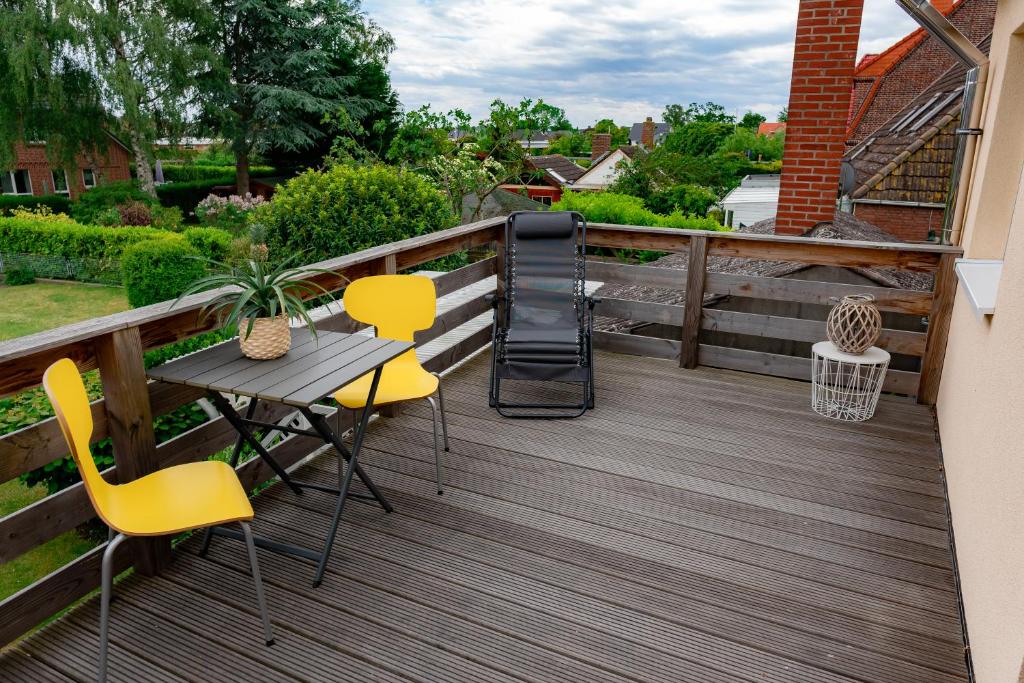 菲曼堡的住宿－Fehmarn Relax，木制甲板上配有桌椅