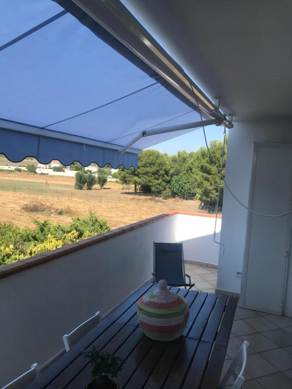 a balcony with a bench and a view of a field at Villa Raffa Salento in Maruggio