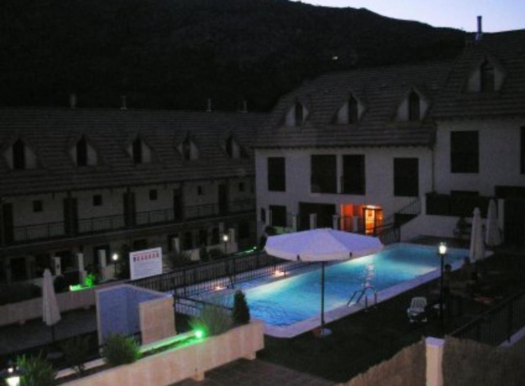 una piscina frente a dos edificios por la noche en Ariosa, en Arroyo Frío