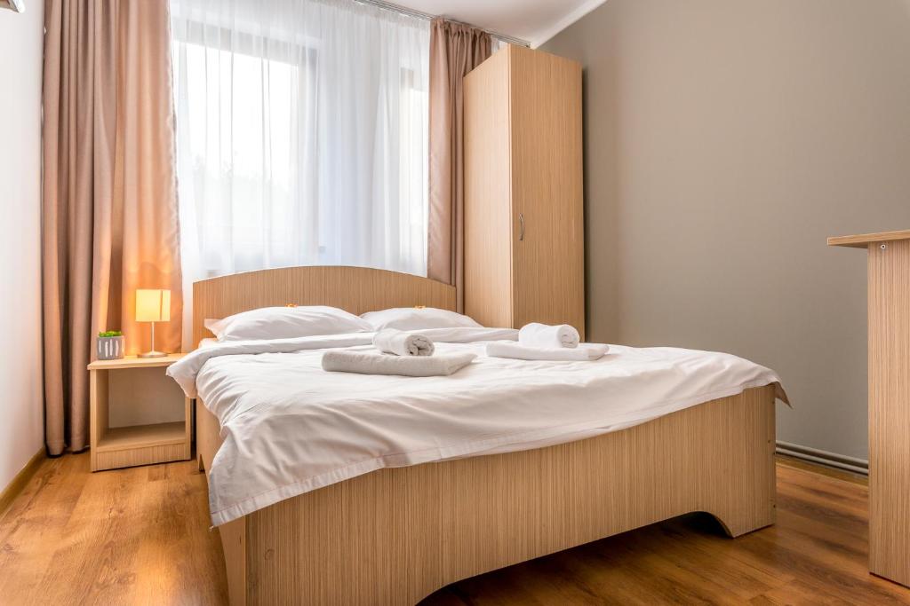 a bedroom with a large bed with towels on it at Pensiunea Armonia in Nădăşelu