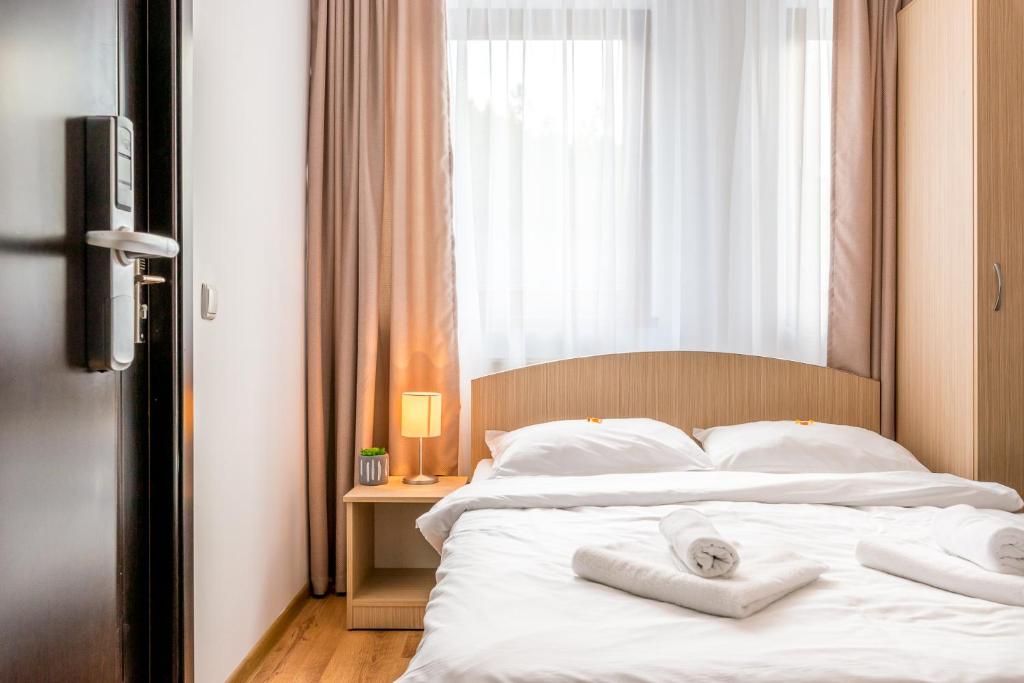 a bedroom with a bed with two towels on it at Pensiunea Armonia in Nădăşelu