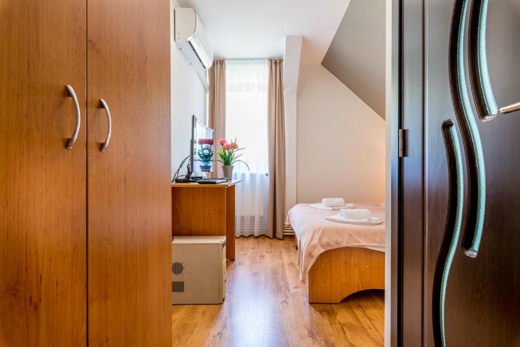 a small room with a table and a bed at Pensiunea Armonia in Nădăşelu