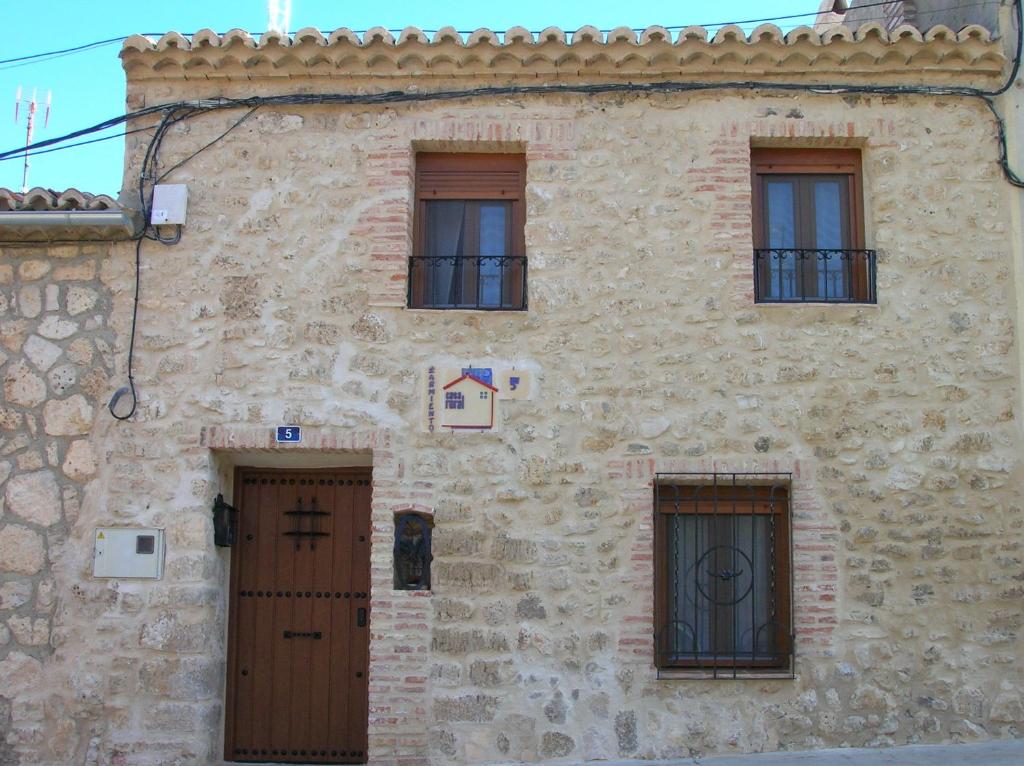 un edificio in pietra con quattro finestre e due porte di Casa Rural Sarmiento a Cubillas de Santa Marta